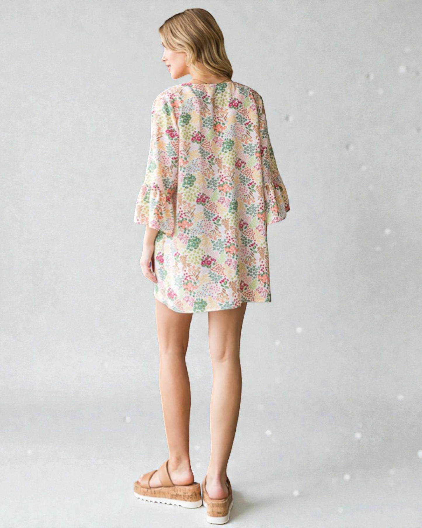 Woman wearing a floral dress with a plain background