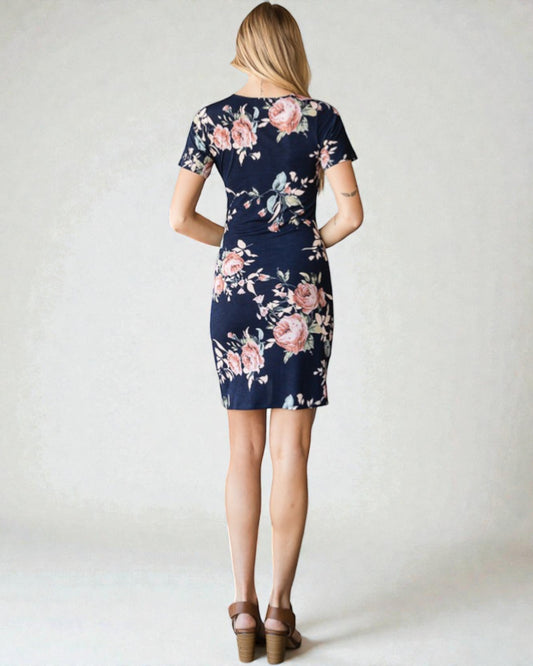 Woman wearing a navy floral dress on a white background