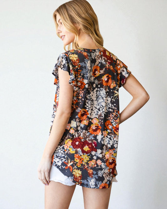 Woman wearing a floral print top with a plain background