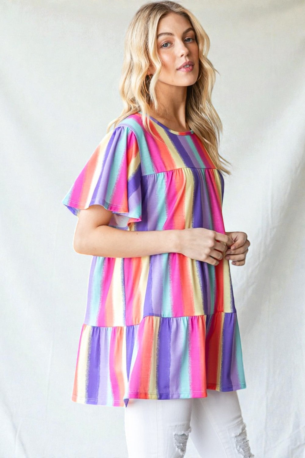 Woman wearing a colorful striped dress against a white background
