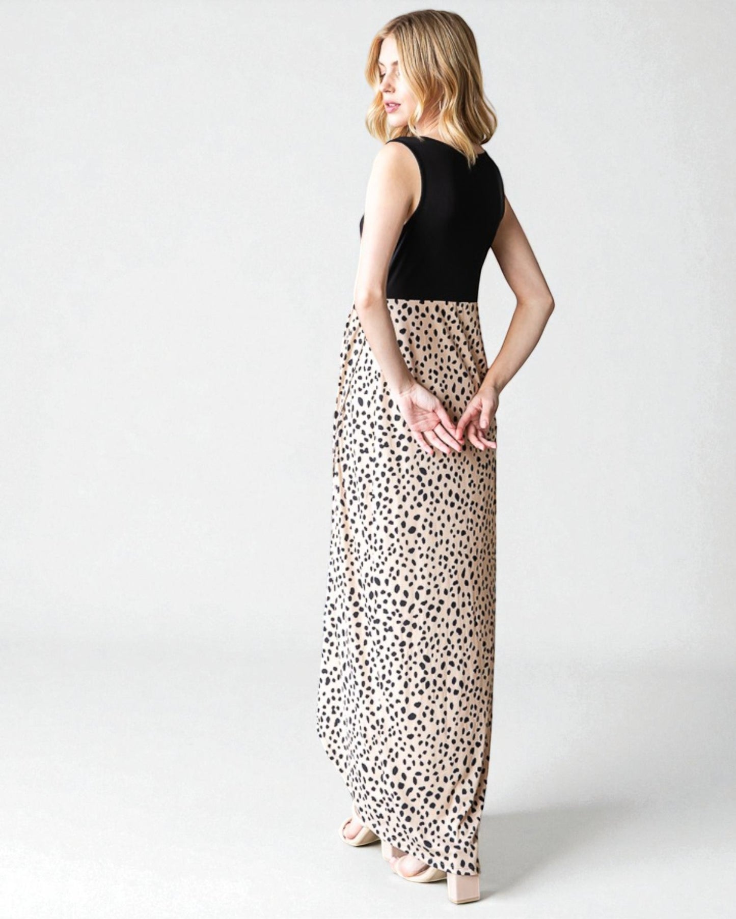 Woman wearing a black sleeveless top and leopard print skirt on a white background