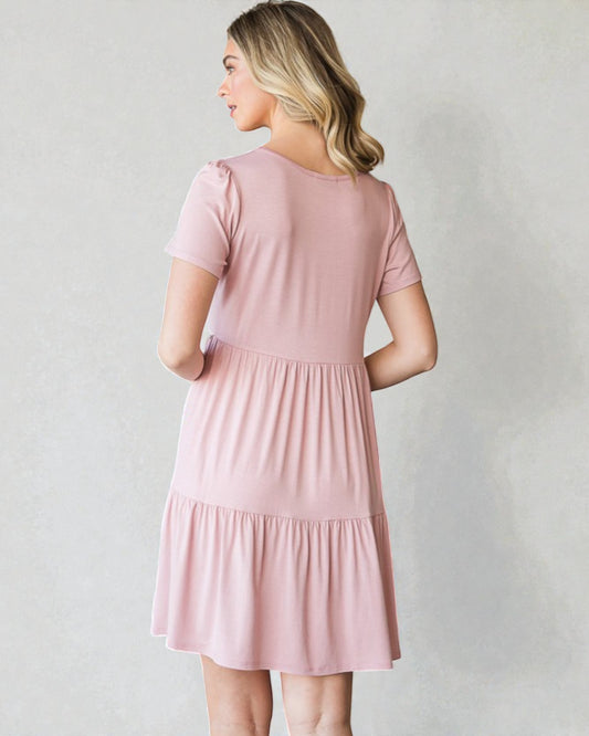 Woman wearing a pink dress against a plain background