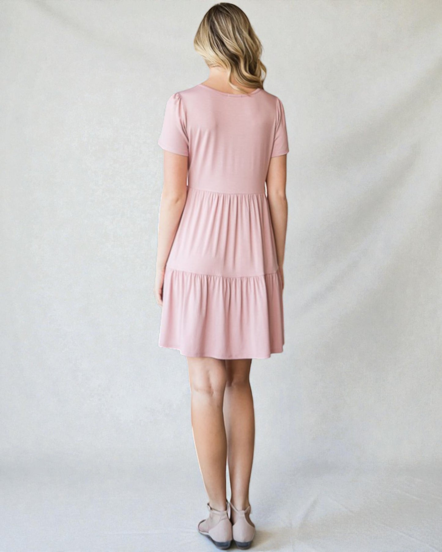 Woman wearing a pink dress against a plain background