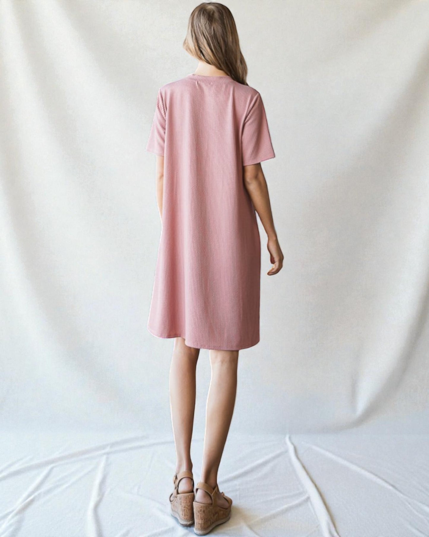 Woman wearing a pink dress against a white background