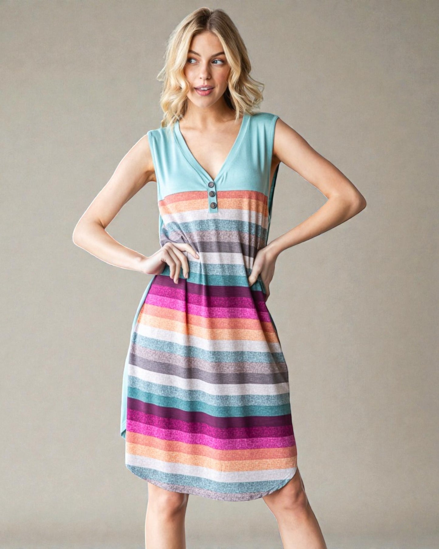 Woman wearing a colorful striped dress against a plain background
