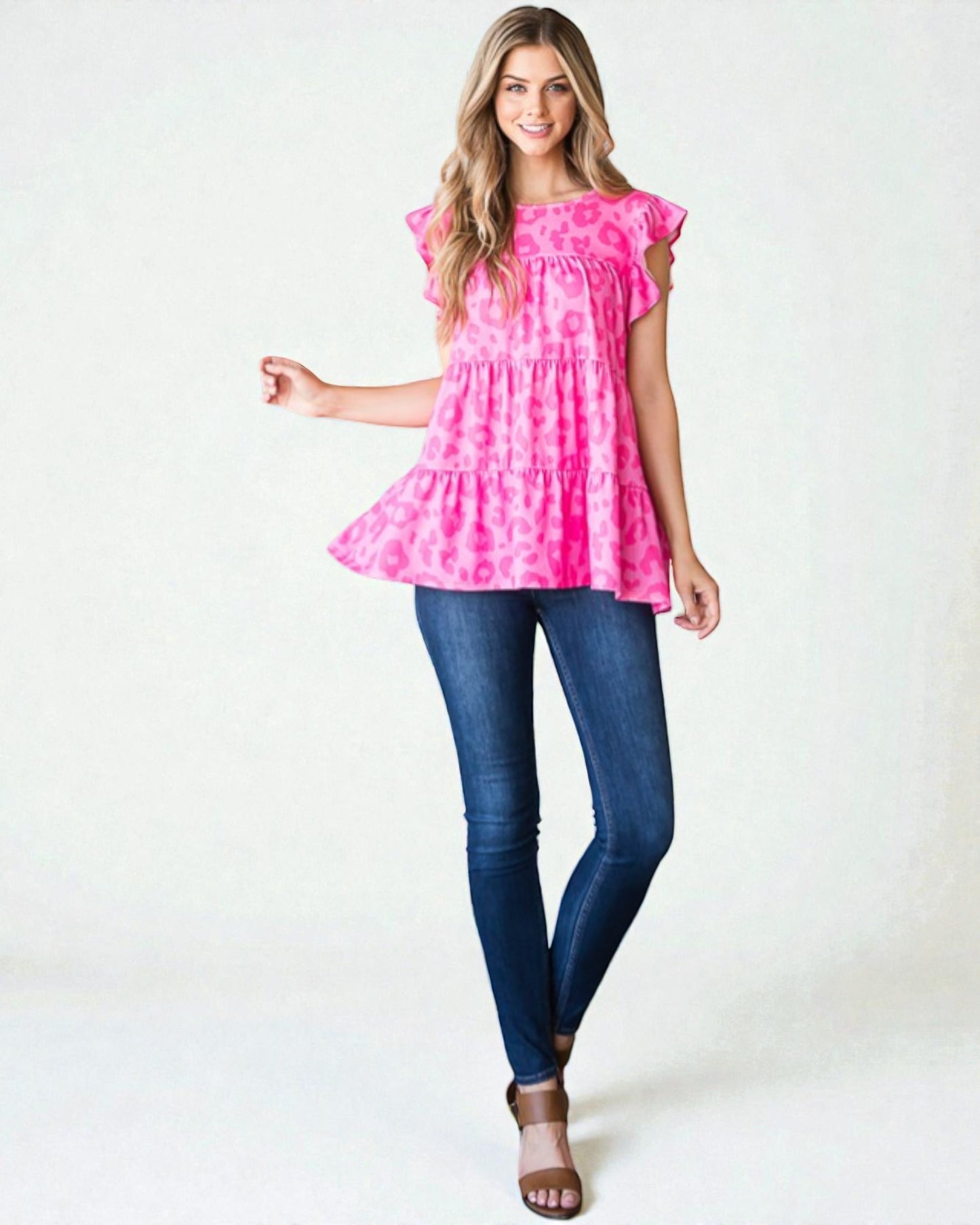 Woman wearing a pink tie-dye top and blue jeans on a white background
