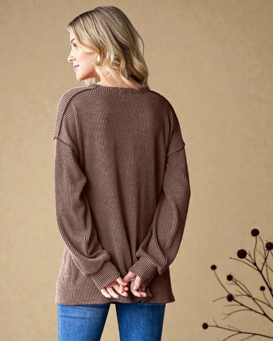 Woman wearing a brown ribbed sweater against a beige background