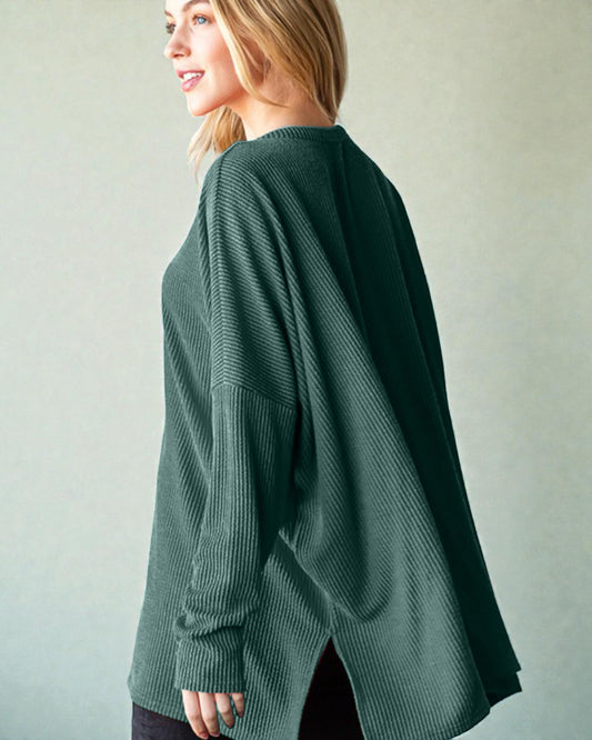 Woman wearing a green sweater against a plain background