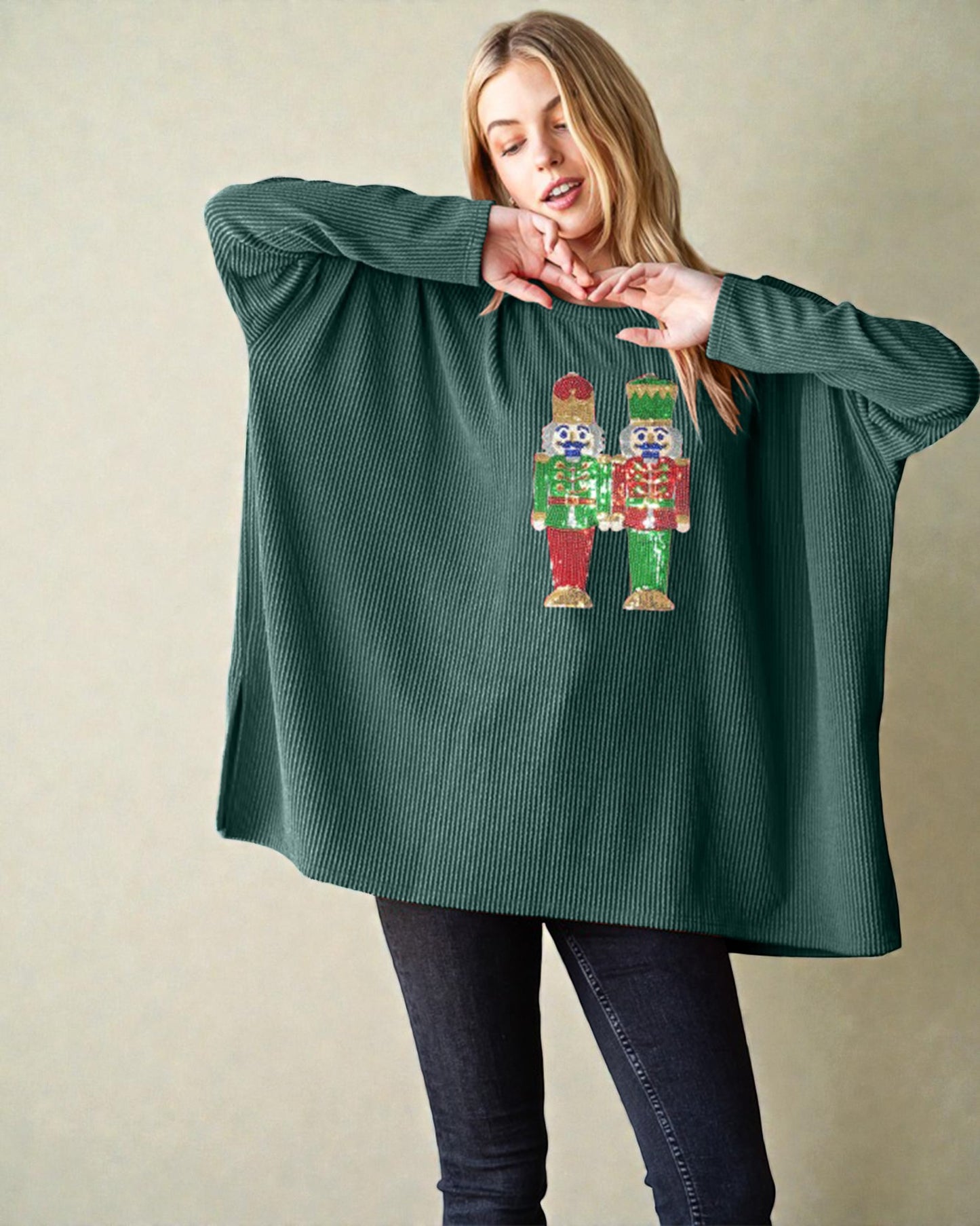 Woman wearing a green sweater with a nutcracker design on a beige background