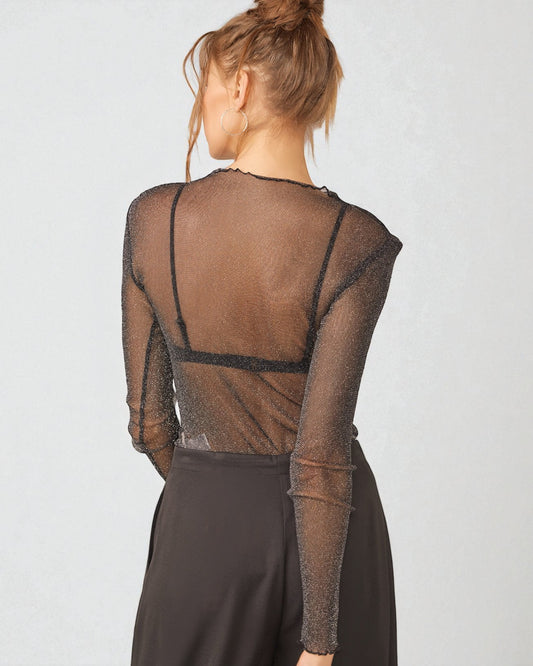 Person wearing a sheer brown top with long sleeves on a light gray background