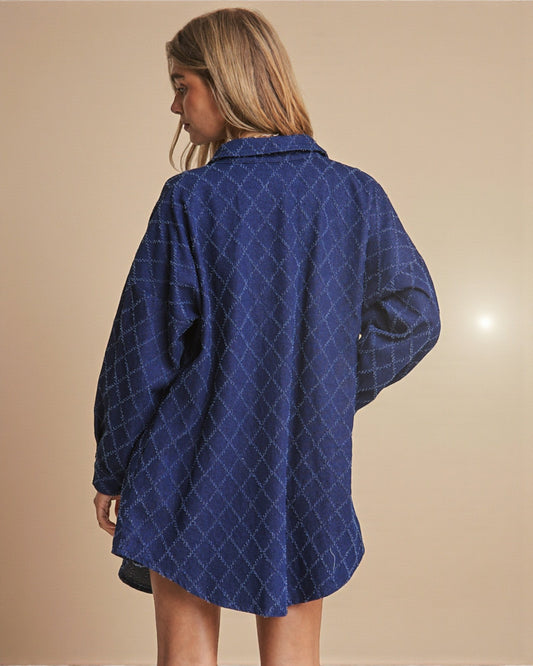 Person wearing a blue diamond patterned shirt against a beige background