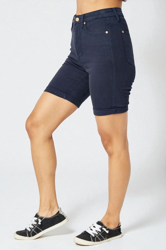 Person wearing navy blue shorts on a white background