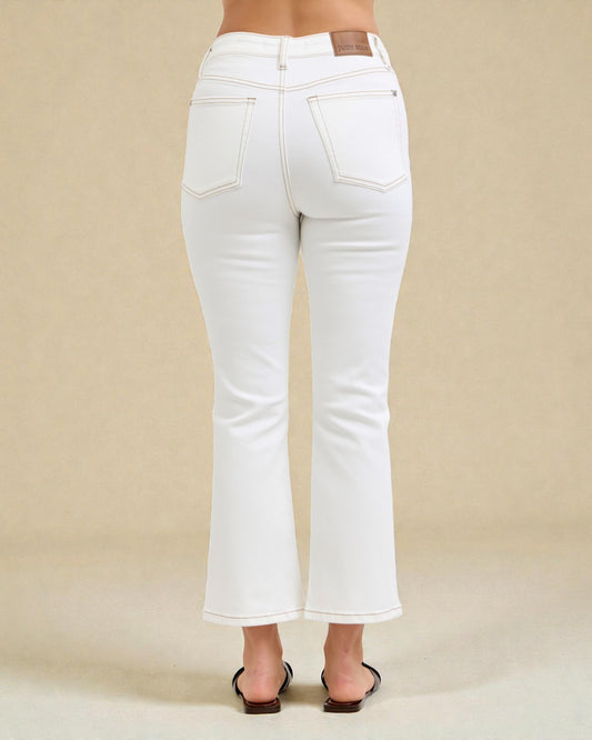White jeans worn by a person on a beige background