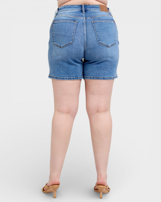 Blue denim shorts worn by a person on a white background