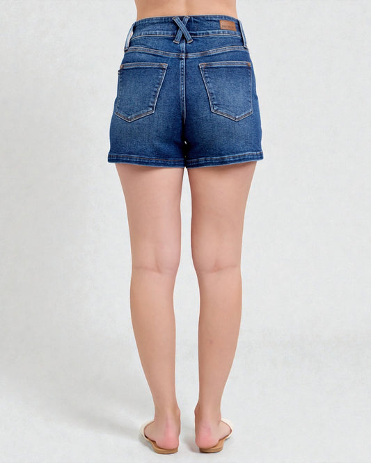 Blue denim shorts worn by a person on a white background
