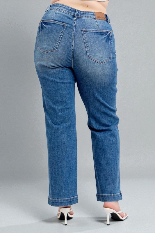 Blue jeans worn by a person on a gray background