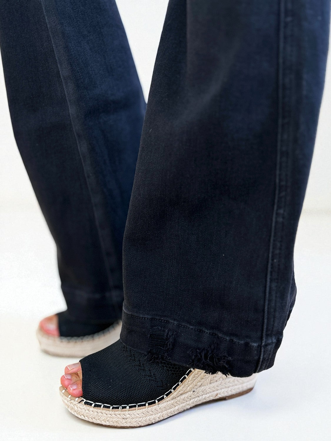 Black jeans worn by a person on a white background