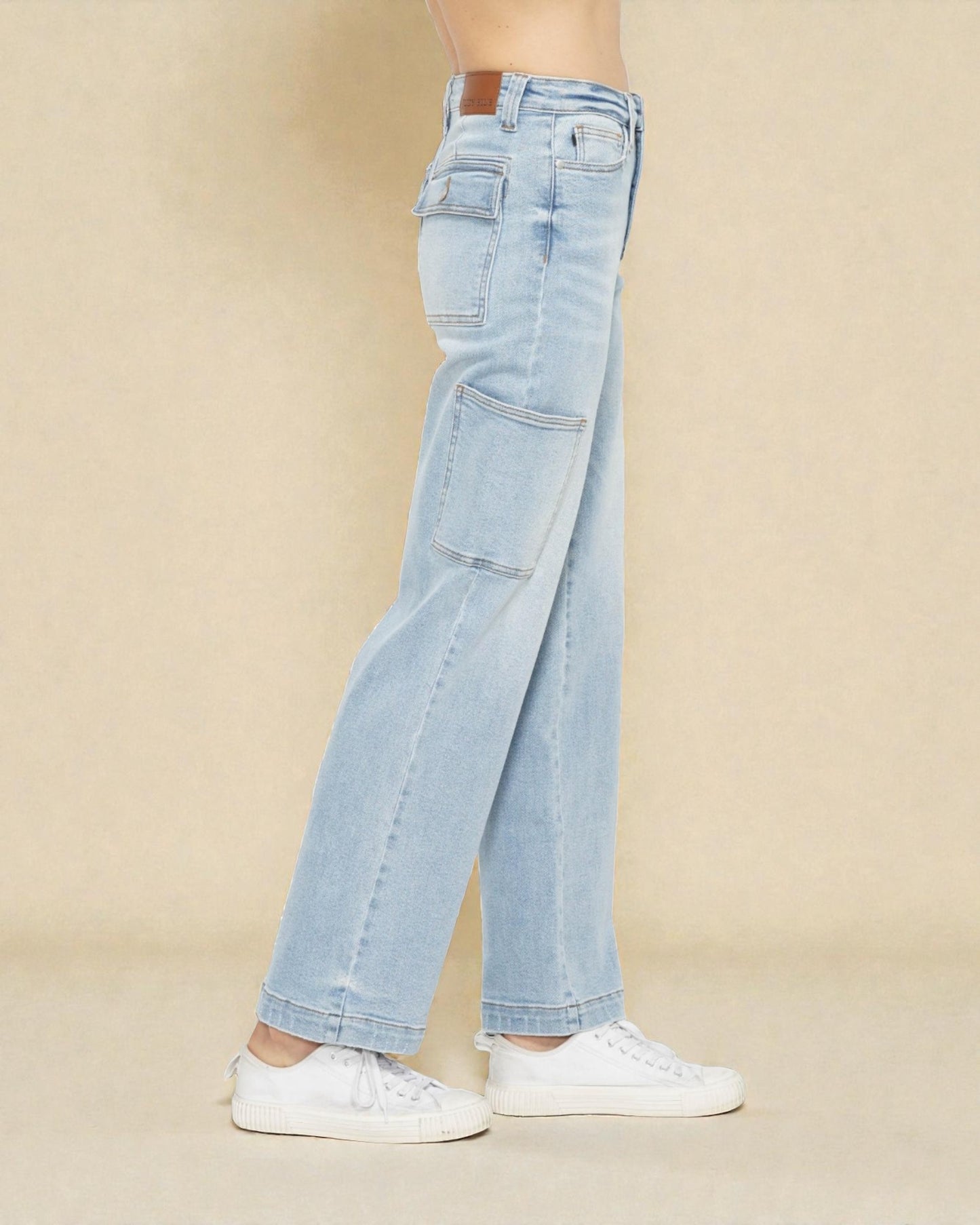 Light blue jeans worn by a person on a beige background