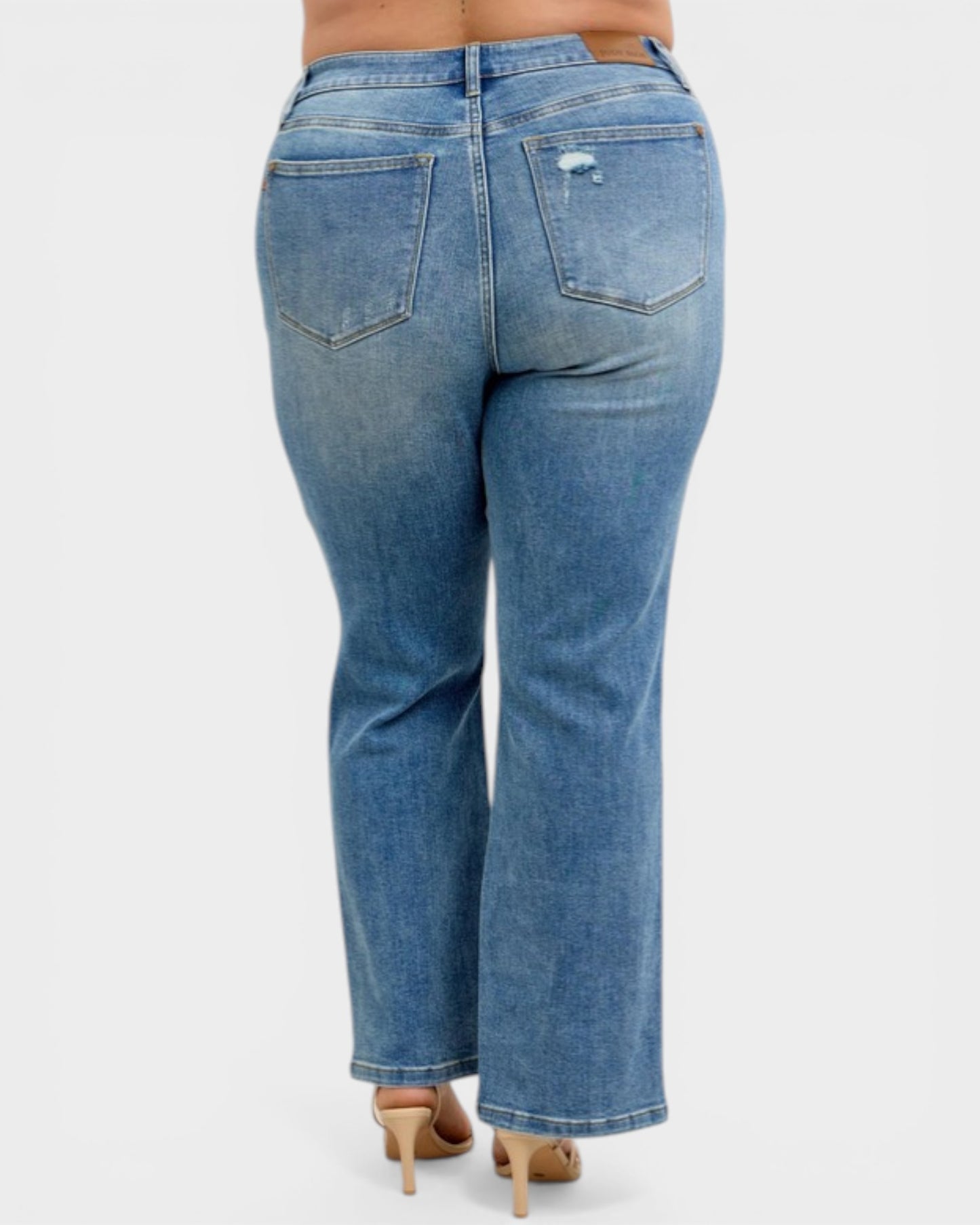 Blue jeans worn by a person on a white background