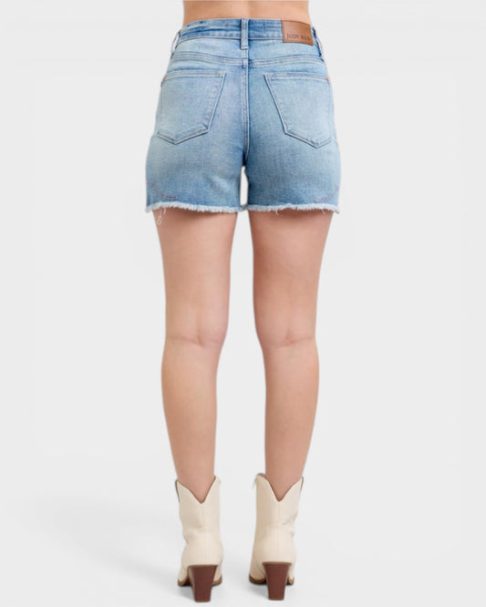 Denim shorts worn by a person on a white background