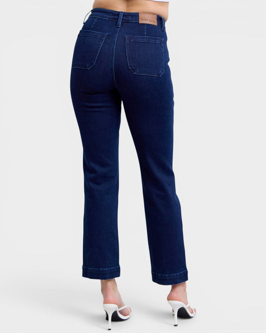 Dark blue jeans worn by a person on a white background