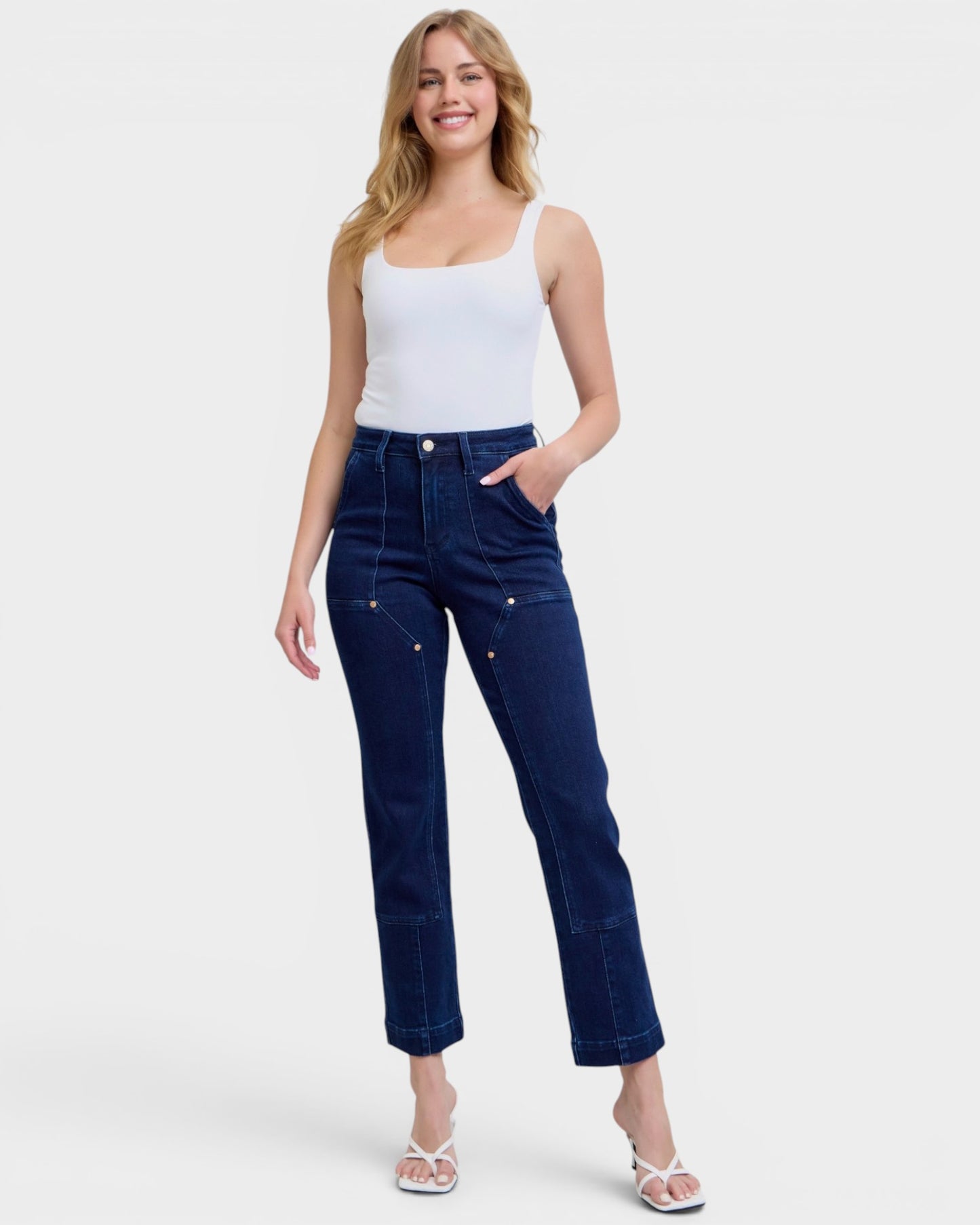 Woman wearing blue jeans and a white top on a white background