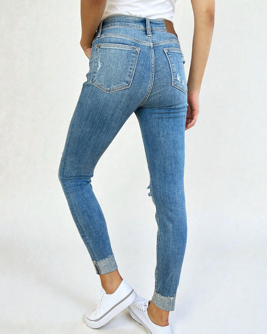 Blue jeans worn by a person on a white background