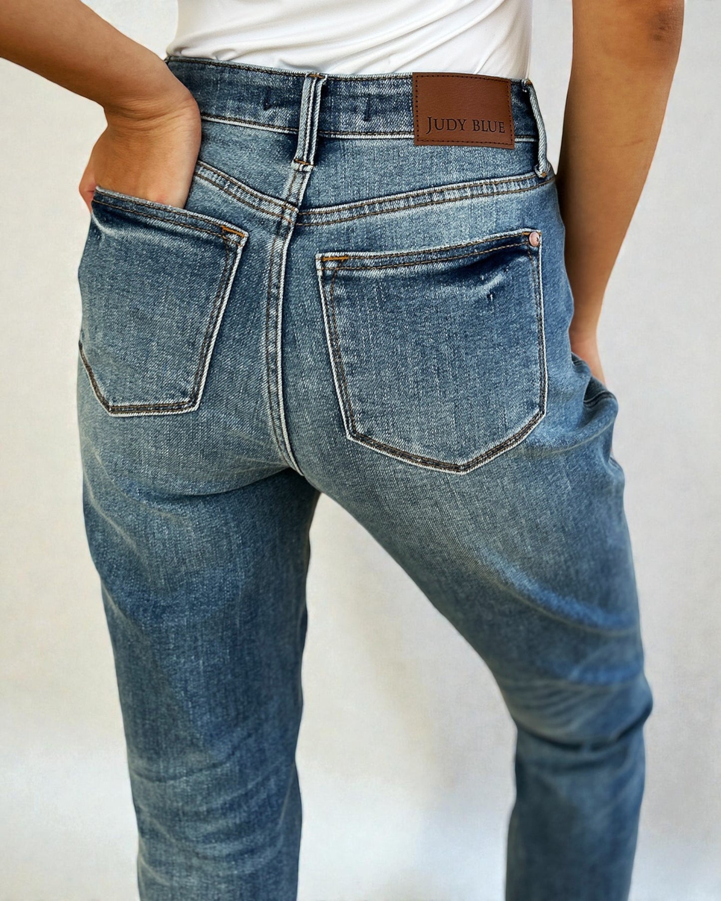 Blue jeans with a visible brand label on a plain background