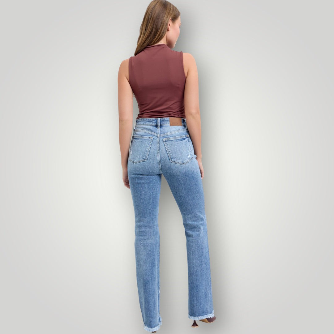 Person wearing blue jeans and a maroon top against a light gray background