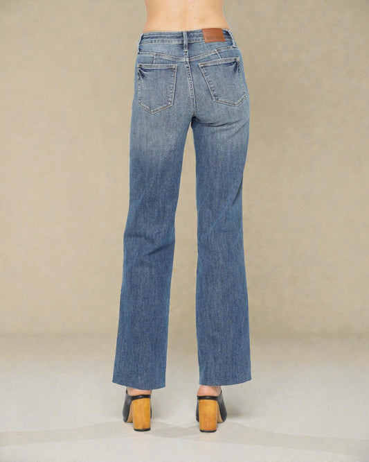 Blue jeans worn by a person on a beige background