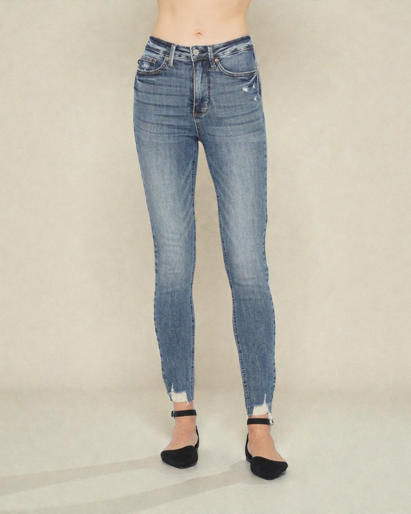 Blue jeans worn by a person on a plain background