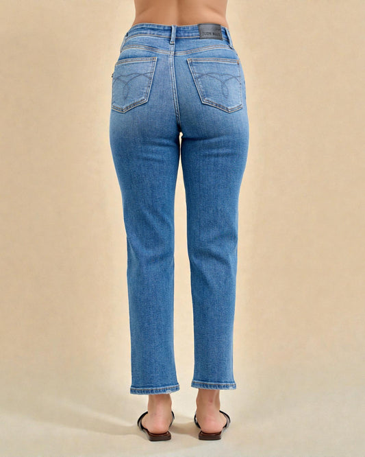 Blue jeans worn by a person on a beige background