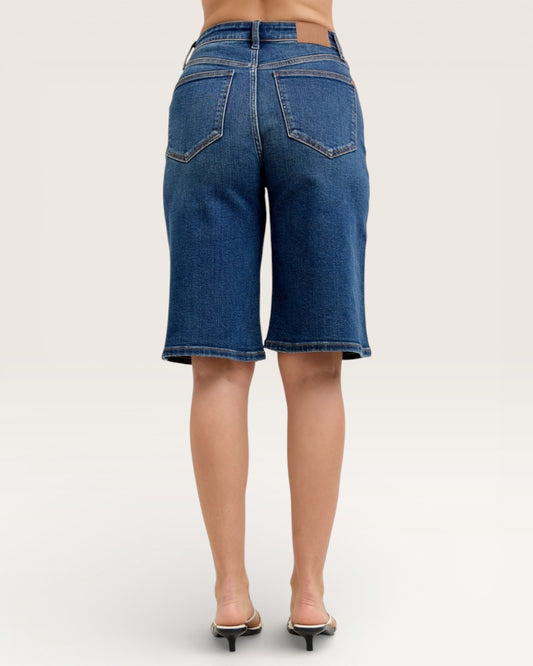 Blue denim shorts worn by a person on a white background