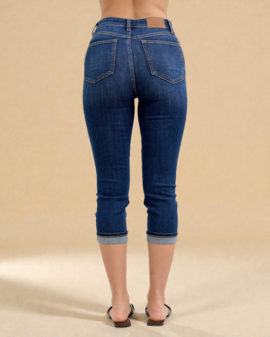 Blue jeans worn by a person on a beige background