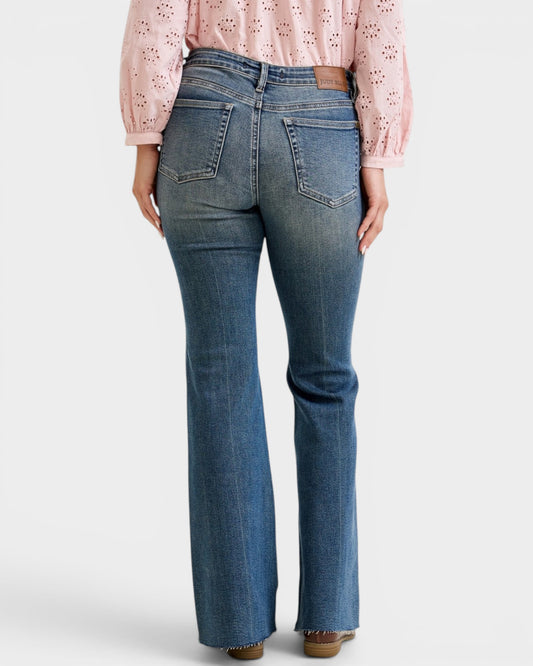 Person wearing blue jeans and a pink blouse on a white background