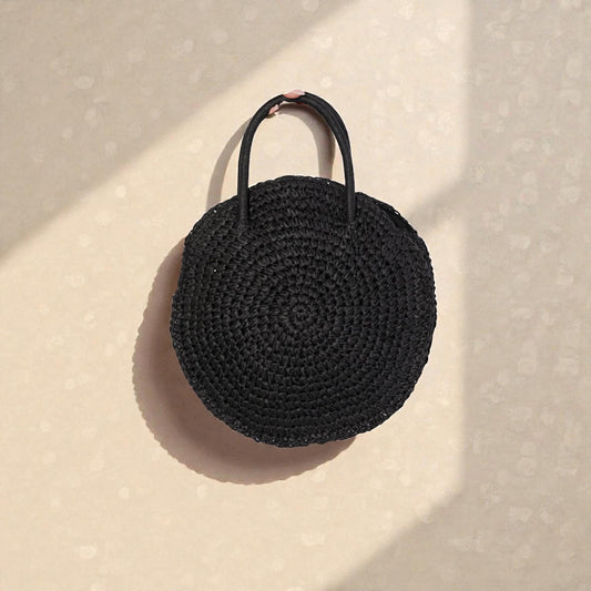 Black woven handbag on a beige background