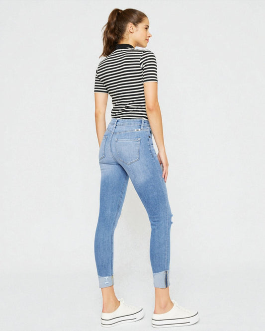 Woman wearing a striped shirt and blue jeans on a white background