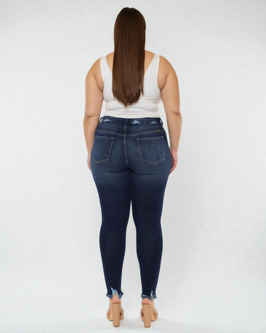 Person wearing dark blue jeans and a white tank top on a white background