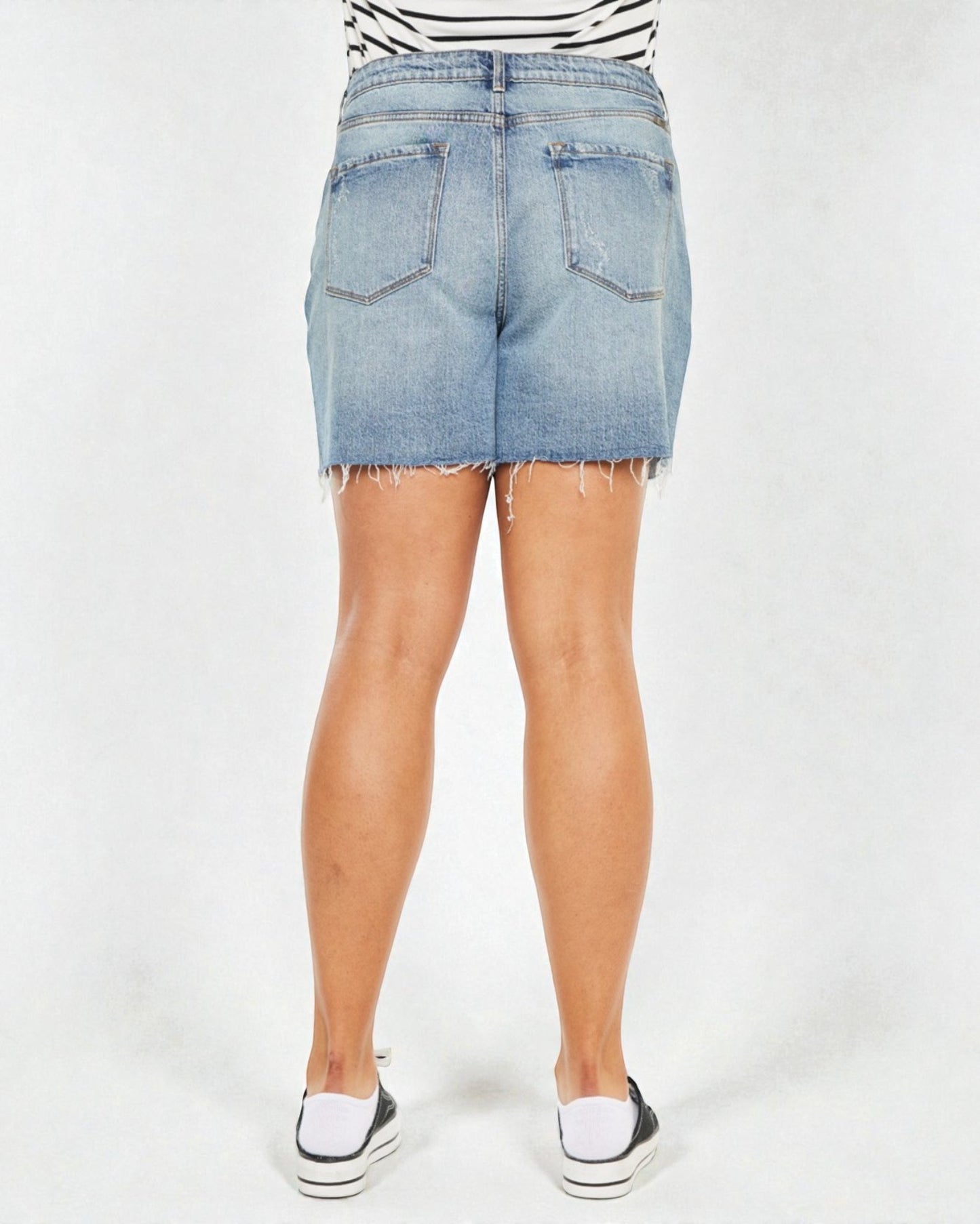 Denim shorts worn by a person on a white background