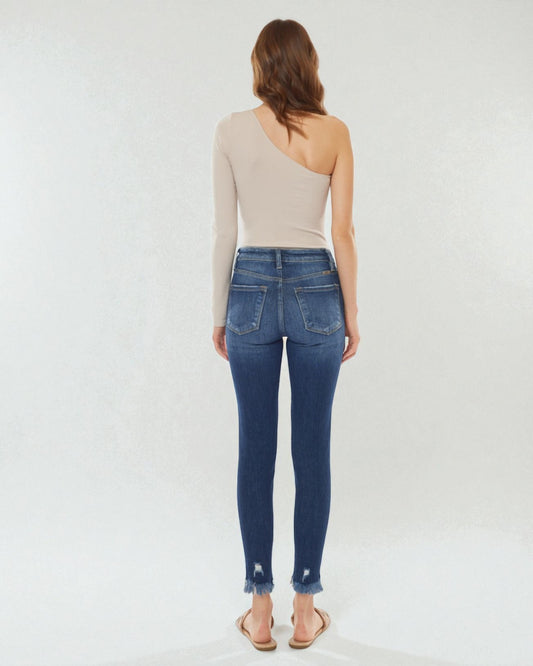 Woman wearing blue jeans and a beige top on a white background