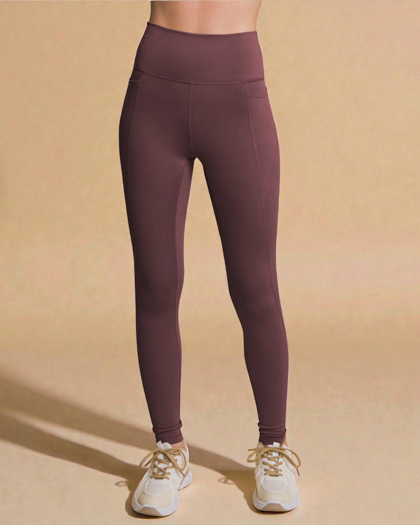 Purple leggings worn by a person on a beige background