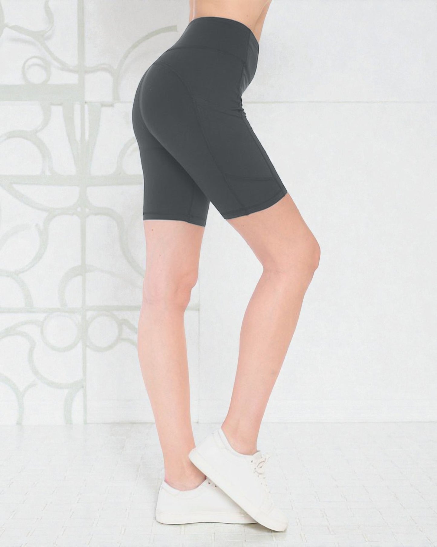 Person wearing dark gray high-waisted shorts on a light background