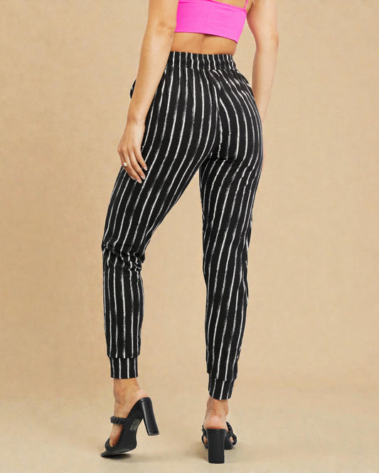 Black and white striped pants worn by a person on a beige background