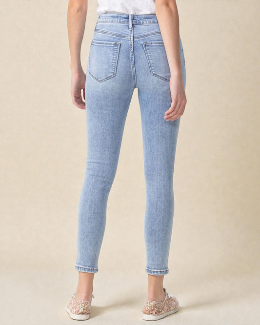 Light blue jeans worn by a person on a beige background