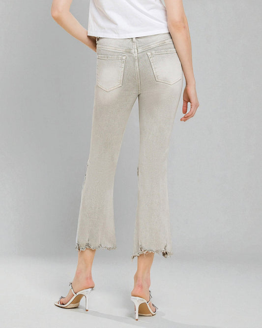 Light-colored jeans worn by a person on a gray background