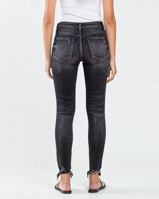 Person wearing black denim jeans on a white background