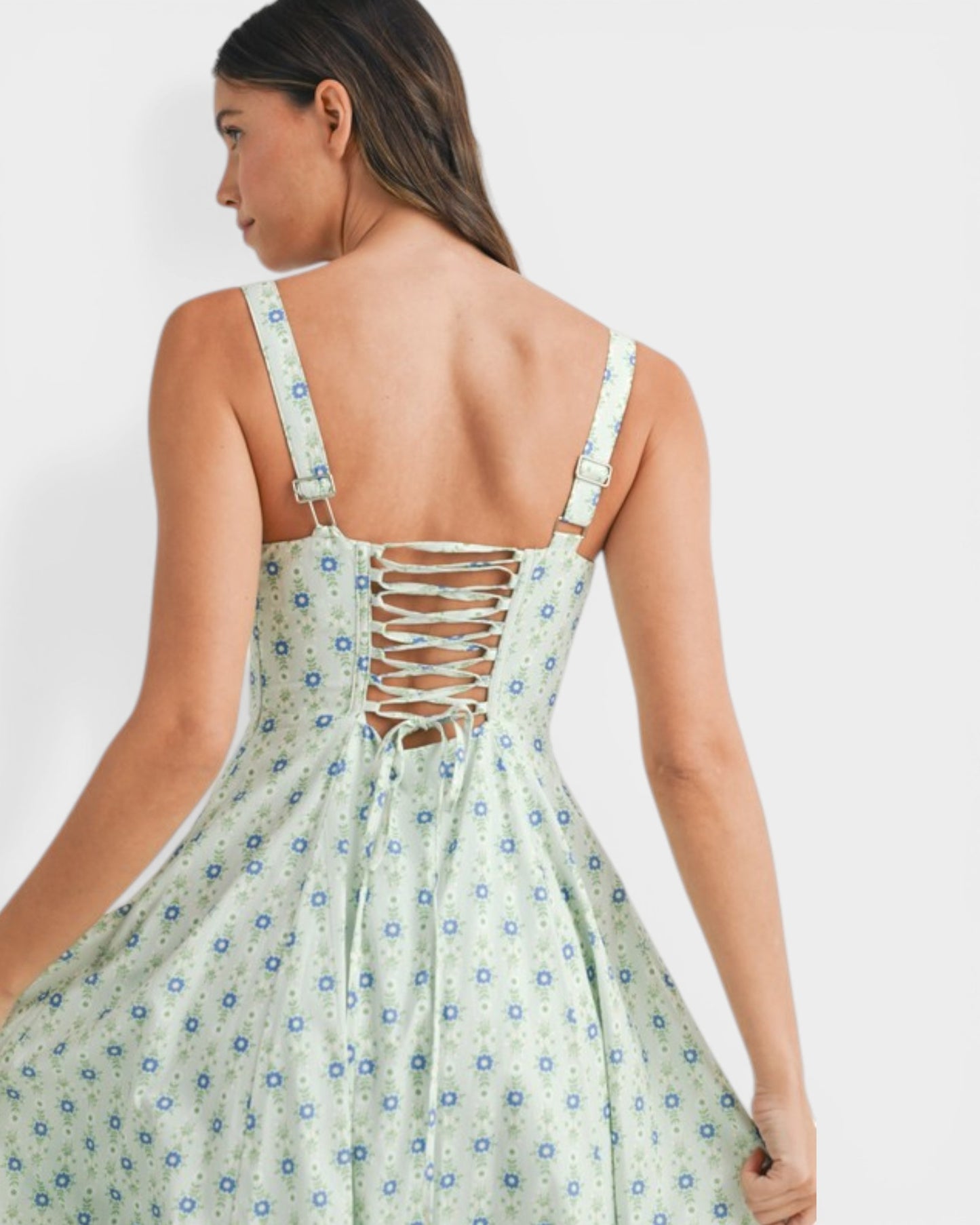 Woman wearing a floral dress with a backless design on a white background