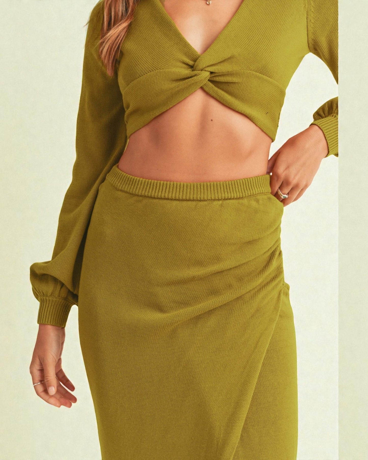 Green knit outfit with a tied top on a light background