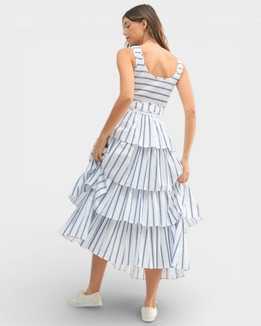 Woman wearing a blue and white striped dress on a light gray background