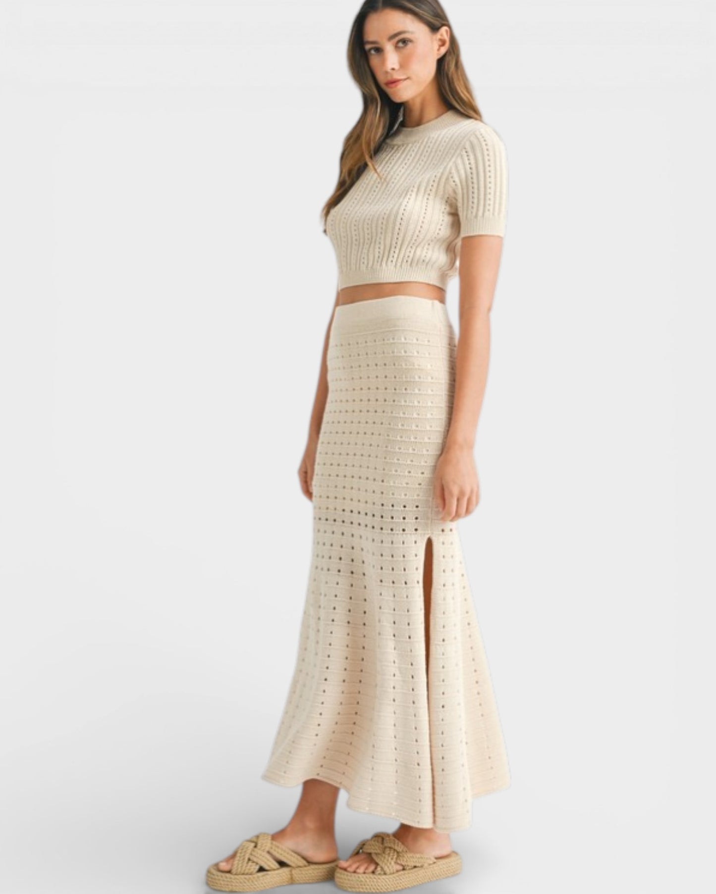 Woman wearing a beige knit two-piece set on a white background